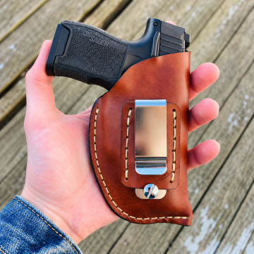 SIG Sauer P365 brown leather holster displayed on rustic wood