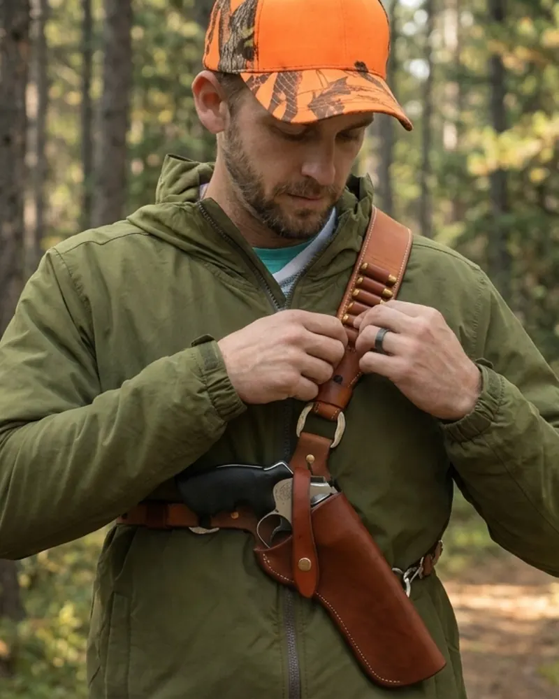 Funda tipo bandolera de cuero marrón con trabillas para revólver y cartucho en un tocón de bosque